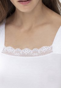Witte tanktop met een delicate kantafwerking bij de halslijn, met een gladde, zachte textuur en een getailleerd ontwerp.