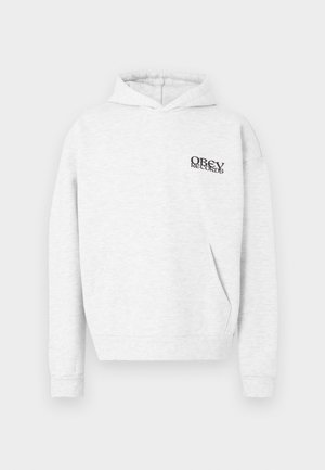 Hanorac gri deschis din material moale, cu buzunar frontal. Are un logo negru "OBEY RECORDS" pe piept. Mâneci lungi și glugă cu șnur.