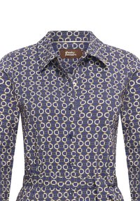 Camicia blu navy con bottoni caratterizzata da un motivo geometrico a cerchi color crema e blu scuro, con colletto a punta e dettaglio con cintura in vita.