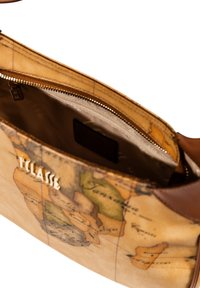 Sac en cuir avec un imprimé carte vintage. Accents marron avec un compartiment zippé à l'intérieur. Doublure de couleur claire avec une étiquette de logo.