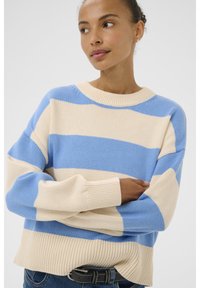 Pulover tricotat în dungi, de culoare albastră și crem, având un guler rotund ribbat, o croială lejeră și mâneci largi. Textura este netedă și moale.