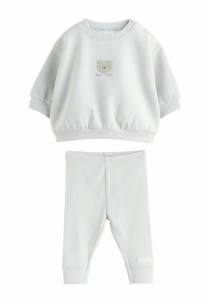 Weißes Baby-Outfit-Set mit einem Sweatshirt, das ein Teddybärgesicht und den Text "bear hugs" zeigt, kombiniert mit gerippten Hosen.