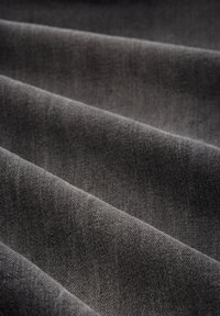 Tecido cinza escuro com uma textura suave, exibido em dobras. O entrelaçamento é apertado, mostrando uma superfície lisa e uniforme.
