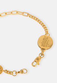 Gold-toned bracelet with elongated links, a round charm engraved with "Don Ed Hardy designs," and a secure clasp.