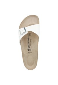 Mule blanche avec une seule sangle réglable, boucle métallique, semelle intérieure texturée et informations sur la taille et la marque imprimées sur le pied.