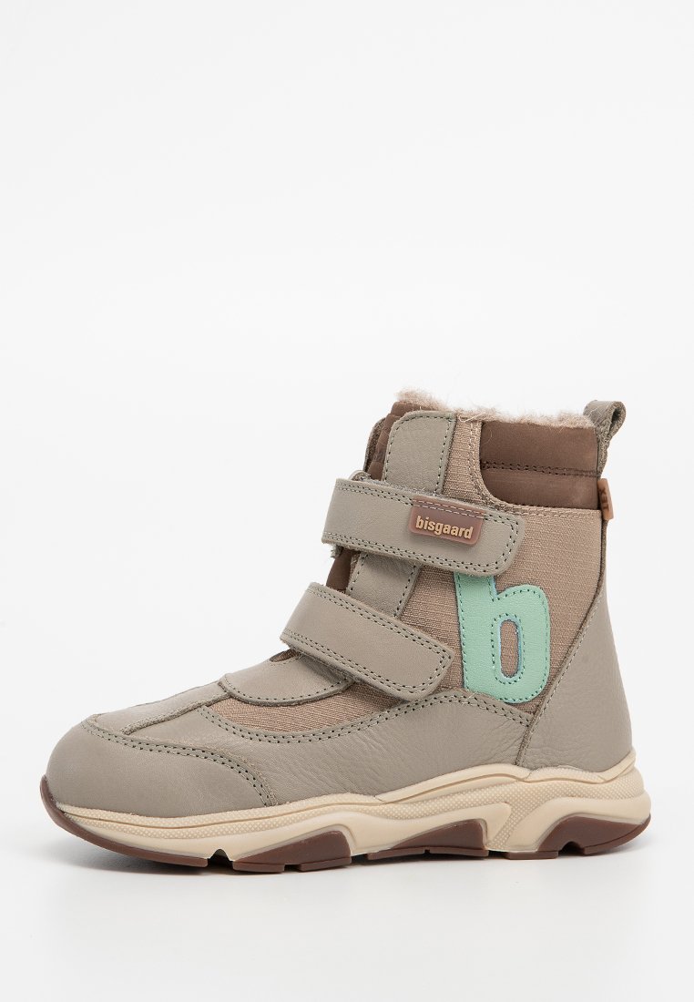 Barndojer i ljusgrått läder med bruna detaljer. Har två kardborreband, ett turkos bokstav "b" och en texturerad sula.