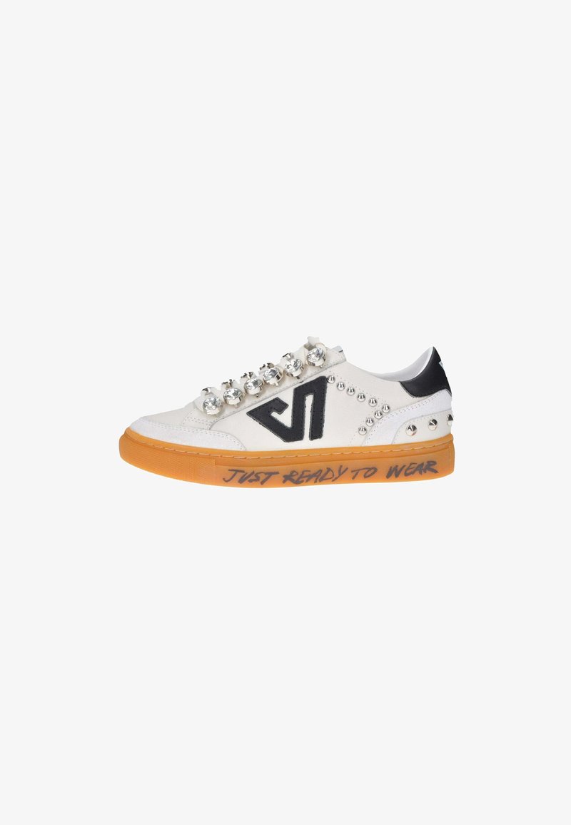 Sneaker bianco con superficie testurizzata, dettagli neri, decorazioni con borchie e suola arancione. Presenta un'iscrizione: "PRONTO DA INDOSSARE".