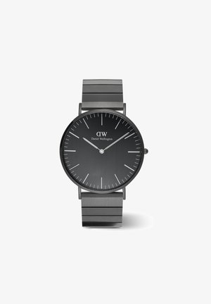 Montre en acier inoxydable noir au design minimaliste. Le cadran rond présente des marqueurs d'heure et des aiguilles en argent. Bracelets à maillons ajustables.