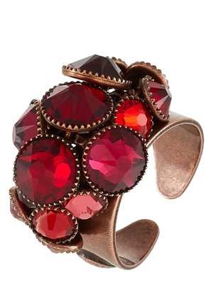 Bague en cuivre ajustable avec des pierres précieuses rouges facettées regroupées de différentes tailles, serties dans des griffes décoratives.
