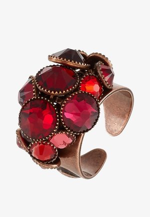 Bague en cuivre ajustable avec des pierres précieuses rouges facettées regroupées de différentes tailles, serties dans des griffes décoratives.
