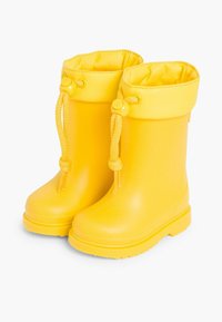 Bottes de pluie jaunes en caoutchouc, avec une pointe arrondie, une semelle texturée pour une meilleure adhérence et un haut repliable avec un système de réglage par cordon.