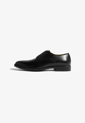 Schwarze Leder-Dress-Schuhe mit einer schlanken, abgerundeten Spitze, minimaler Naht und glatter Oberfläche. Eigenschaften sind ein niedriger Absatz und eine Schnürung.