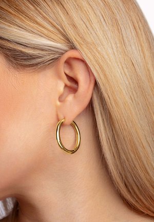 Goldene Creolen mit einer glatten, polierten Oberfläche, in runder Form und sicherem Verschluss, die im durchstochenen Ohr getragen werden.