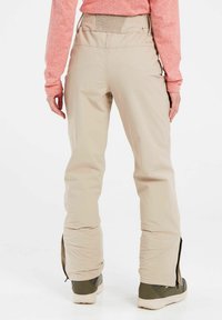 Beige buitenbroek met een relaxed fit, elastische tailleband en ritsen bij de enkels. Gemaakt van lichtgewicht, weerbestendig materiaal.
