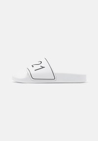Vit halksandal med utpräglad tån, svart nummer "21" på ovansidan, slät yta och strukturerad sula för grepp.