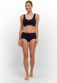 Zwarte sportbeha en bijpassende hipster slip, beide met een contrasterende roze logoband, gladde stof en een eenvoudig ontwerp.