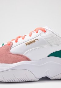 Weißer Sneaker mit pinkem Wildleder und grünen Akzenten. Obere aus Mesh und Synthetik, mit Korallenschnürsenkeln und goldenen Logodetails. Texturiertes Laufsohle.