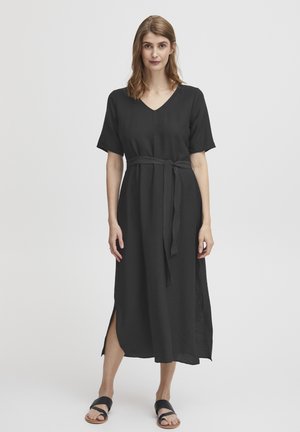 Schwarzes, knielanges Kleid mit kurzen Ärmeln, V-Ausschnitt und einem Bindegürtel in der Taille; verfügt über seitliche Schlitze für Bewegungsfreiheit. Glatte Textur.