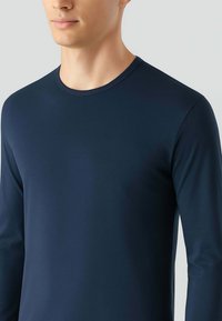 T-shirt a maniche lunghe blu navy con collo rotondo, realizzato in tessuto leggero e morbido. Presenta una silhouette aderente e un design minimalista.