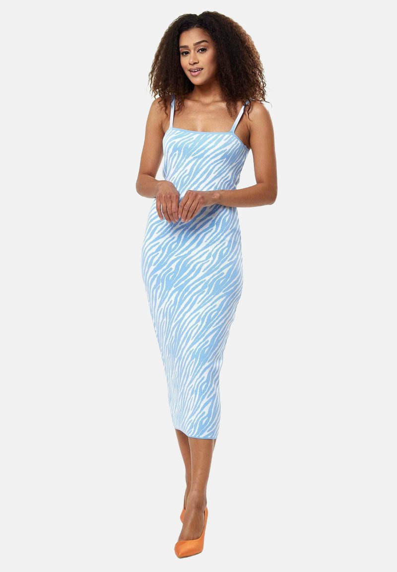 Light blue midi dress with white zebra stripes, made of fitted fabric, featuring thin straps and a square neckline, paired with orange heels.