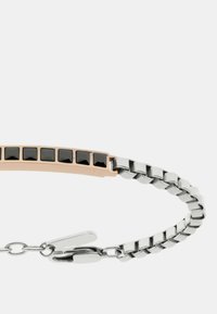 Bracciale in metallo argento con un accento in oro rosa, caratterizzato da pietre nere rettangolari e un design a catena, fissato con una chiusura.