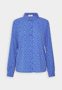 Chemise bleu à manches longues avec un col, couverte de pois blancs. Dispose d'une fermeture à boutons sur le devant et d'une coupe décontractée.