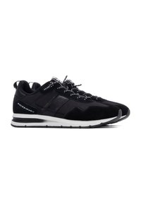 Zapatillas negras con una combinación de ante y malla, con cordones blancos con manchas negras, un collar acolchado y una entresuela blanca.