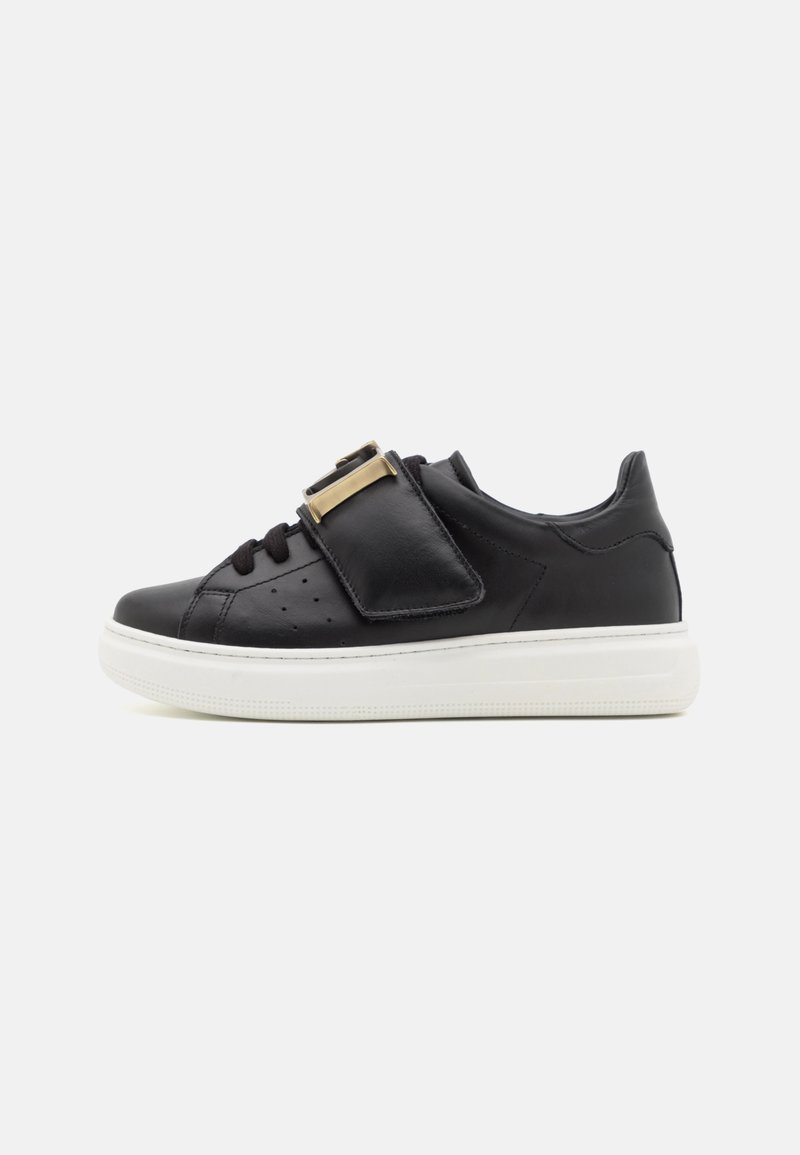Sneaker in pelle nera con design a lacci, accenti in hardware dorato, suola in gomma bianca, dettagli perforati sui lati.