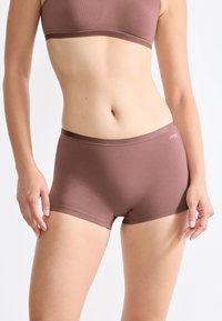 Bruna sömlösa underkläder i boxerstil, med en slät textur och en tät passform. Diskret logotypdetalj på midjebandet.
