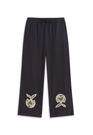 Crne široke hlače ravnog kroja s elastičnim pojasom i vezicama, ukrašene bež apstraktnim čipkastim izrezima blizu ruba na obje nogavice.