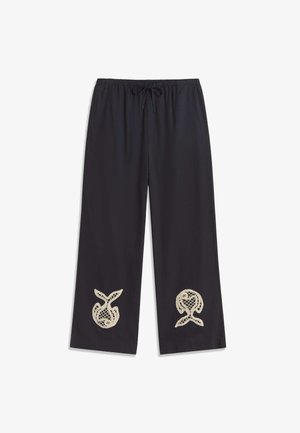 Crne široke hlače ravnog kroja s elastičnim pojasom i vezicama, ukrašene bež apstraktnim čipkastim izrezima blizu ruba na obje nogavice.