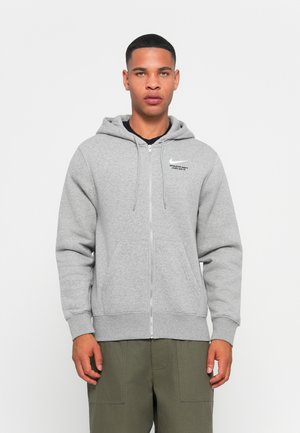 Gray zip-up hoodie made of soft fabric, featuring a drawstring hood, kangaroo pockets, and a Nike logo on the left chest.