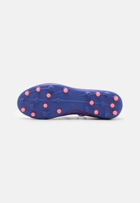 Suola di scarpa da calcio viola con tacchetti rosa, caratterizzata da una superficie texturizzata e modelli di trazione distintivi per una maggiore aderenza sui campi esterni.