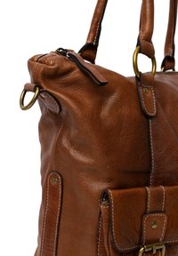 Borsa a mano in pelle marrone con superficie texturizzata, chiusura con zip, inserti in ottone e cuciture bianche. Presenta una tasca frontale con pattina e fibbia.