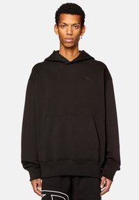 Sudadera con capucha negra hecha de una tela suave, con un bolsillo tipo canguro y un logo sutil en el pecho. Corte relajado con puños acanalados.