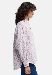 Jasnofioletowa koszula sztruksowa w leoparda, z zapięciem na guziki z przodu, w oversize'owym fasonie oraz jedną kieszenią na piersi.