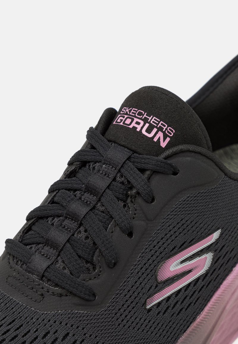 Czarne buty sportowe z siateczkowymi wstawkami, różowymi i srebrnymi akcentami, z amortyzującą podeszwą i systemem sznurowania przez oczka. Z przodu znajduje się logo Skechers.