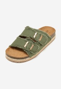 Green fabric slide sandal with frayed edges, two gold-tone buckles, and a tan cushioned insole, featuring a textured outsole for grip.