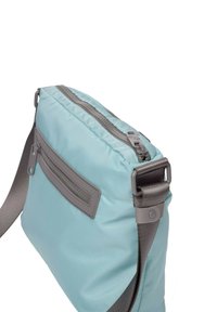 Un sac à bandoulière en nylon bleu clair avec des accents gris, doté d'une poche zippée à l'avant et d'une bandoulière réglable grise, affichant une texture lisse.