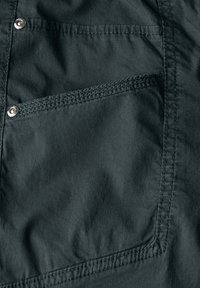 Dark gray fabric with a smooth texture featuring a prominent pocket with stitching and a silver snap button accent.