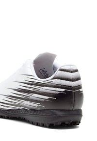 Scarpa da ginnastica bianca con sfumatura nera e strisce diagonali, dotata di suola texturizzata e tallone imbottito per il supporto.