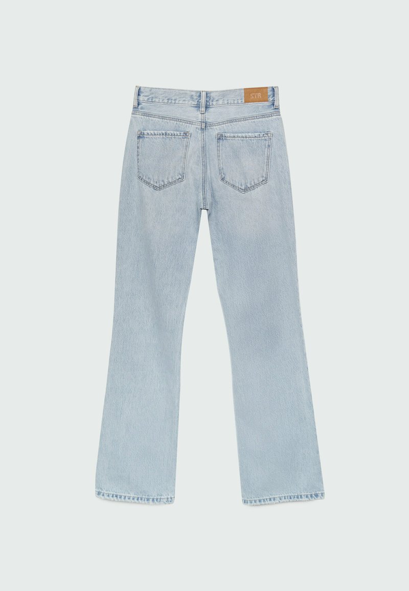 Helle blaue Jeans mit weitem Bein, mittlerer Taille, zwei Gesäßtaschen und einem Aufnäher am Bund. Glatte Textur, gerade Beinöffnungen.