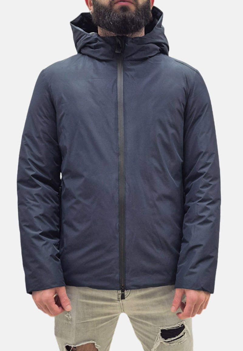 Giacca cappuccio blu navy realizzata in tessuto leggero, con zip frontale e superficie testurizzata. I dettagli includono un cappuccio aderente e maniche lunghe.