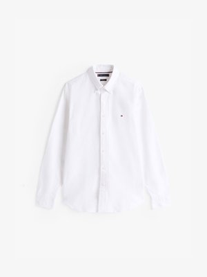 Chemise blanche à manches longues, boutonnée, fabriquée en coton. Elle présente un col évasé, une patte de boutonnage et un petit logo brodé sur la poitrine.
