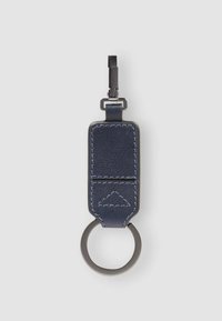 Portachiavi in pelle blu navy con finitura testurizzata, dotato di un anello in metallo argento e di un ampio gancio per il fissaggio. Dettaglio accentato a triangolo trapuntato.