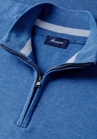 Pull en maille bleu avec demi-fermeture éclair, bande blanche à l'intérieur du col, et étiquette bleu foncé portant l'inscription "Façonnable" au niveau de l'encolure.