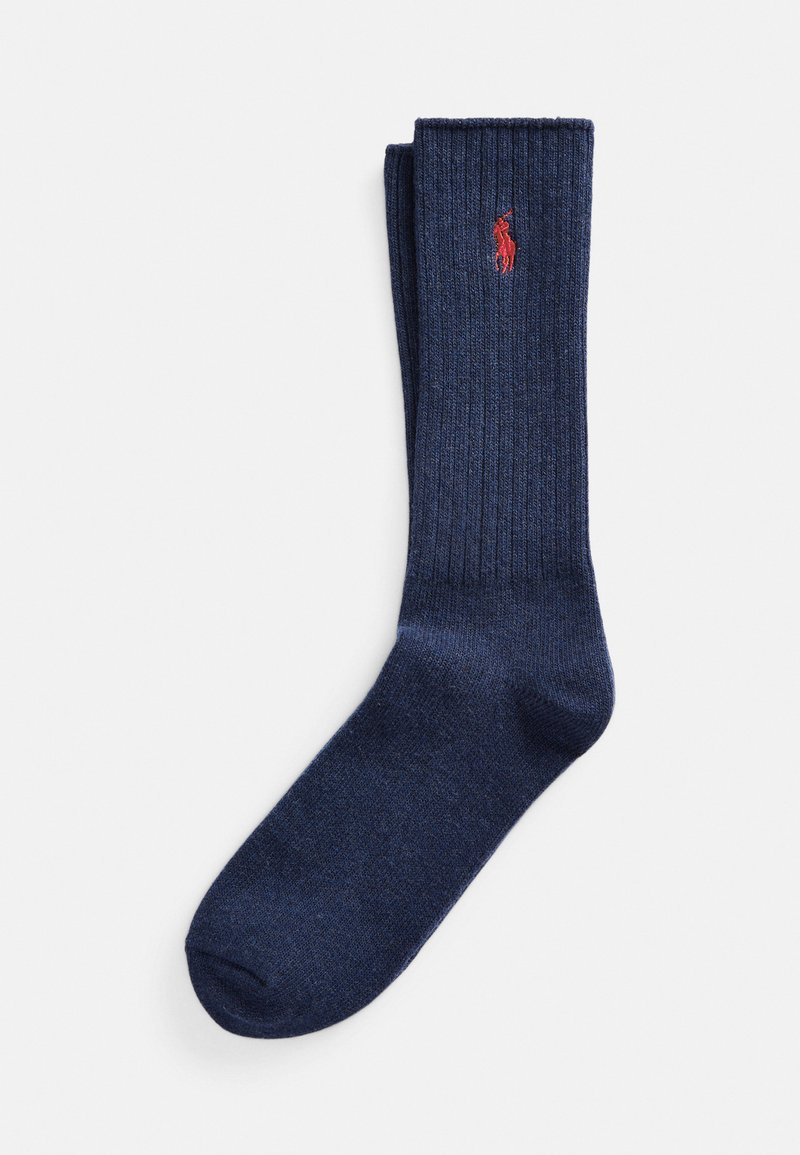 Calzini a coste color navy realizzati in materiale morbido, con un piccolo logo rosso. Il design include una parte superiore a manica rifinita e una consistenza liscia.