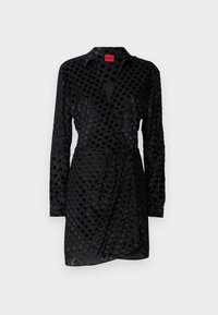 Robe noire à motif à pois, à manches longues, avec un col et un design enveloppant, agrémentée d'une ceinture à la taille. Fabriquée en matériau lisse.