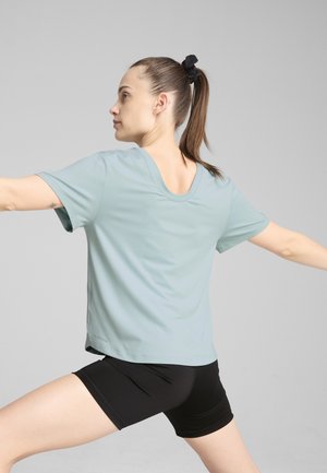 Camiseta atlética de color azul claro con mangas cortas y escote redondo, combinada con pantalones cortos negros. Tela suave, diseño de ajuste relajado.