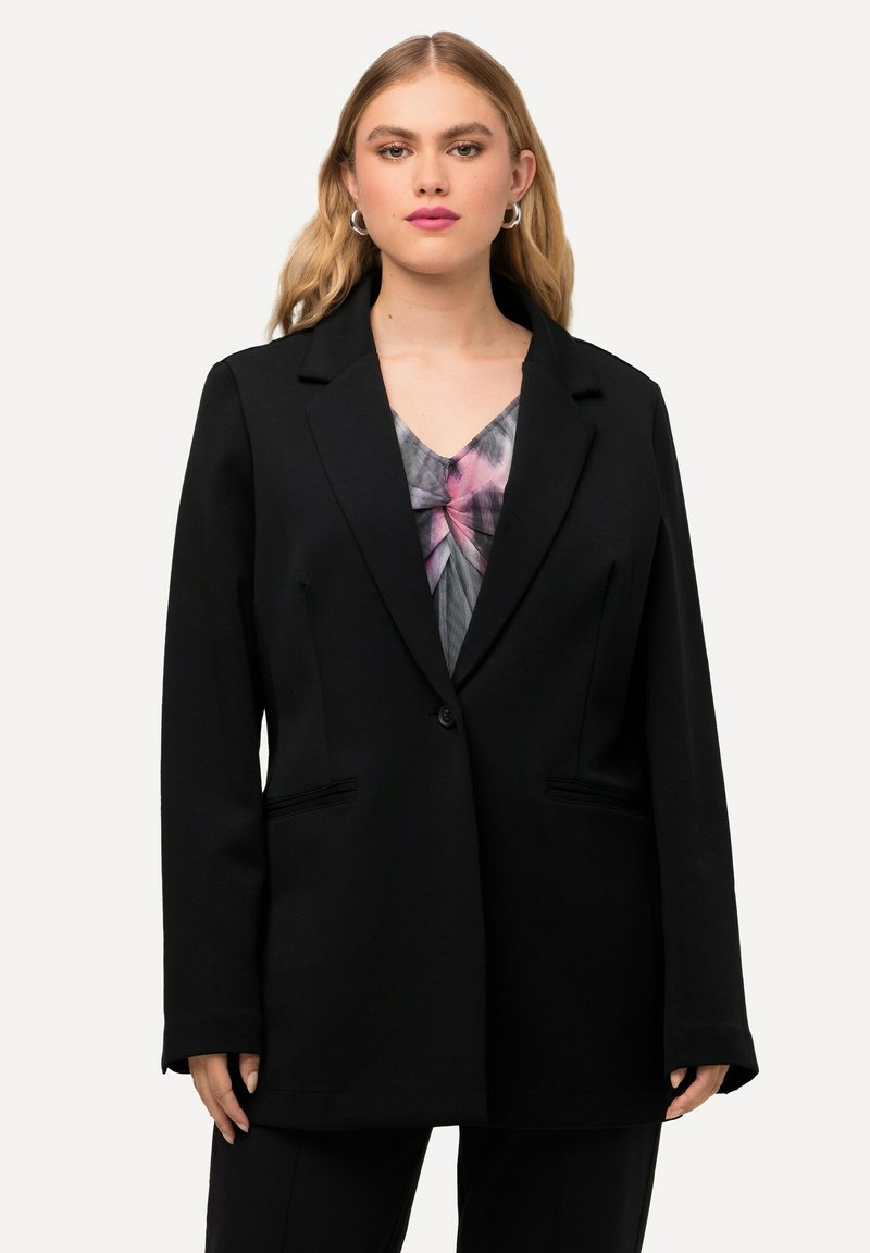 Blazer nero con una vestibilità strutturata, chiusura a un bottone e due tasche frontali. Il tessuto appare liscio con una finitura opaca.